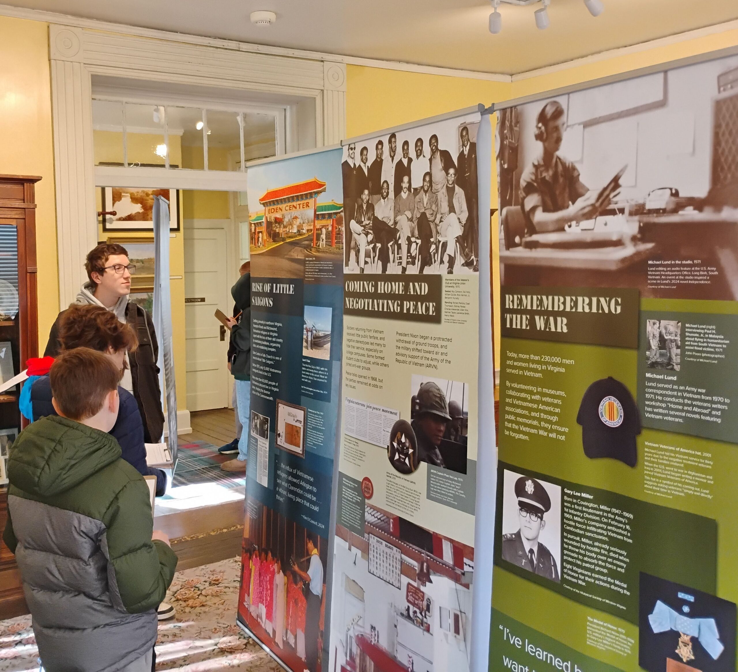 A group of students view exhibit panels on the Vietnam War.